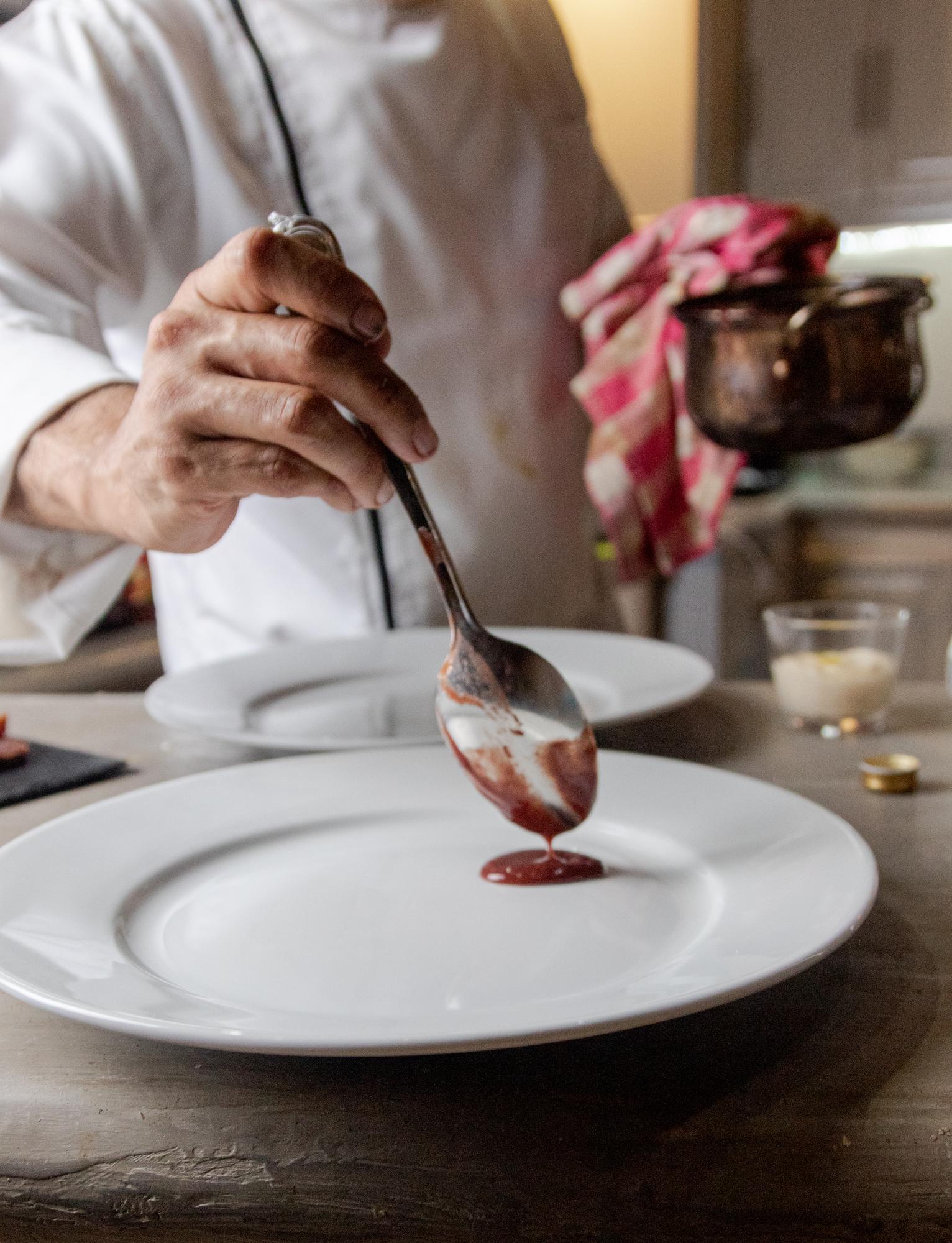 Chef arranging a dessert on a ceramic plate