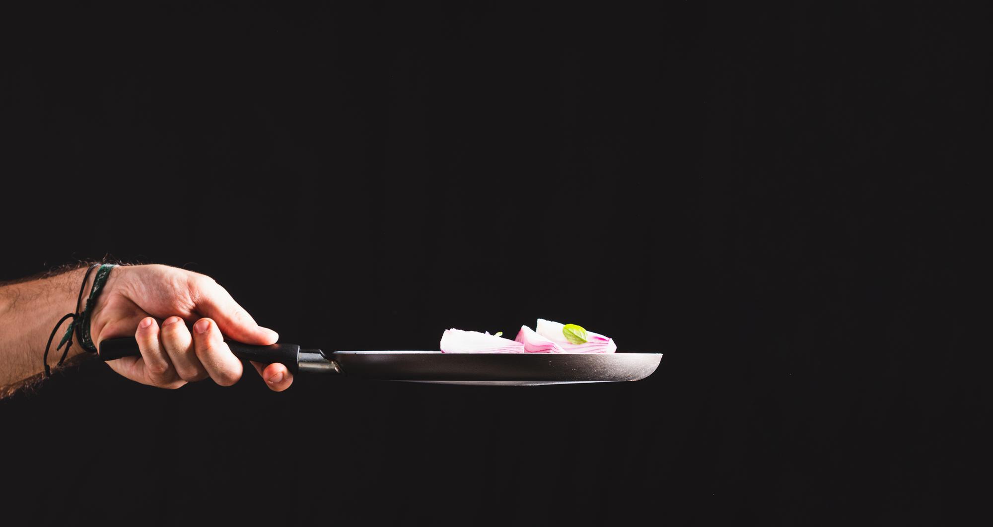 Chef plating a colorful dish on a slate board